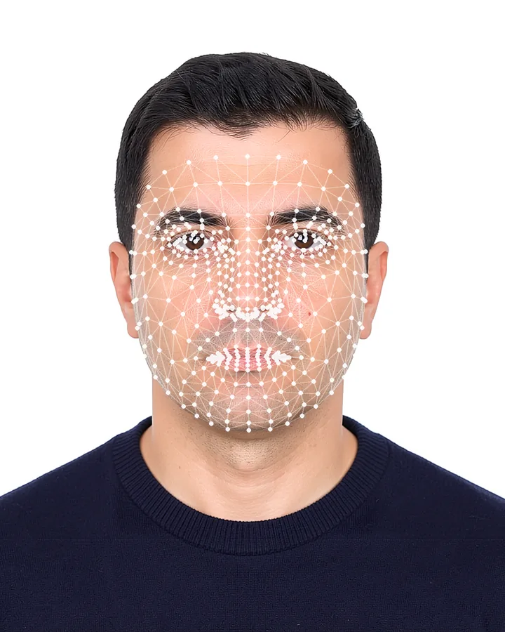 Biometrisches Passfoto eines Mannes in schlichtem dunkelblauem Oberteil vor weißem Hintergrund